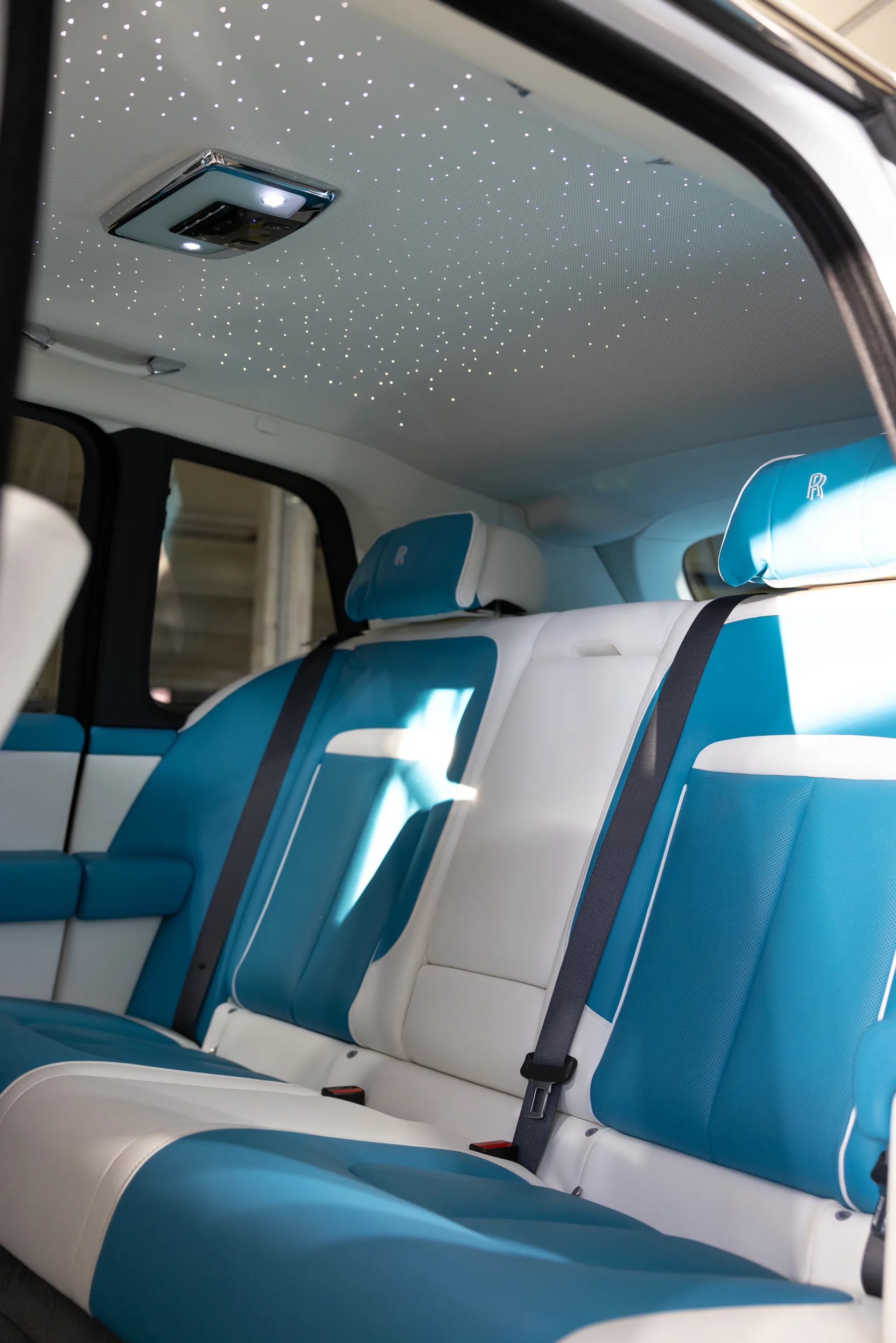 The starlight headliner lit above the Tiffany-style blue and white rear bench of the Rolls-Royce Cullinan Series II