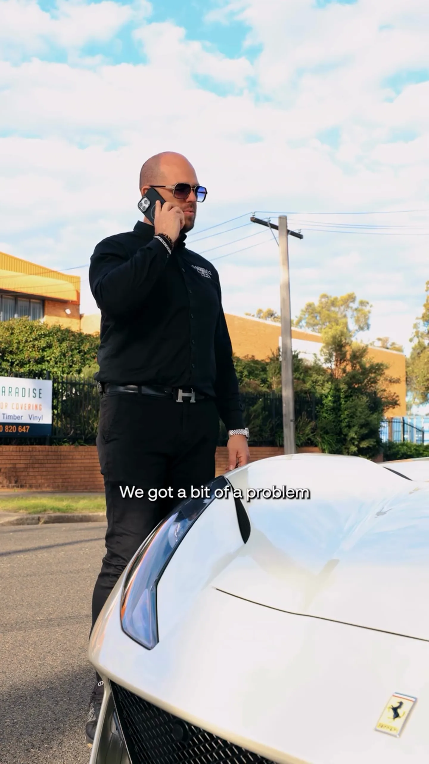 A white Ferrari 812 Superfast stopped kerbside in Sydney with a flat tyre